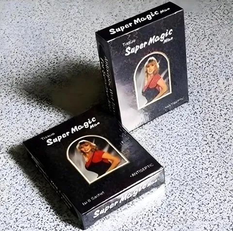 Two black playing card boxes with a woman in red on the front, on a speckled surface.