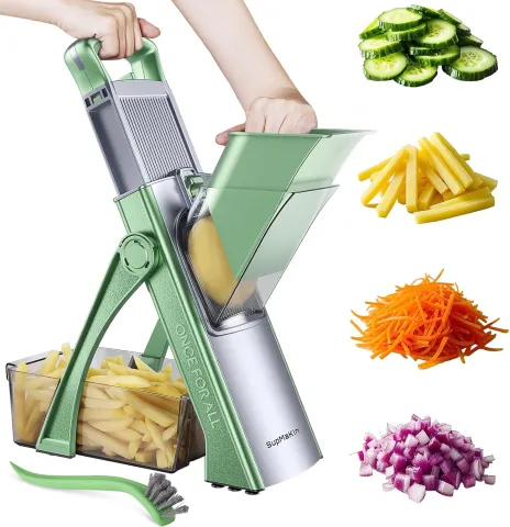 Green vegetable slicer with hand-operated handle and chopped veggies in various shapes nearby.