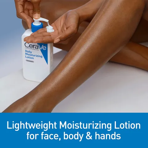 Person applying lotion to leg from a Cerave bottle on a white surface.