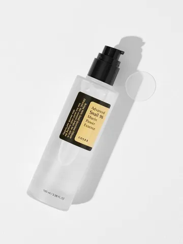 Clear plastic skincare bottle with black pump and beige label on a white background.