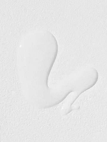 White liquid spill on a textured white surface.