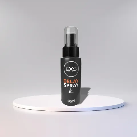 Black bottle of EXS Delay Spray with a clear cap on a white platform.
