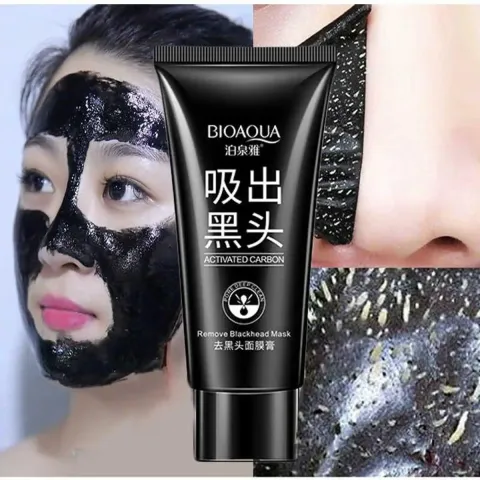 Woman with black peel-off face mask, skincare product tube, close-up of mask texture.