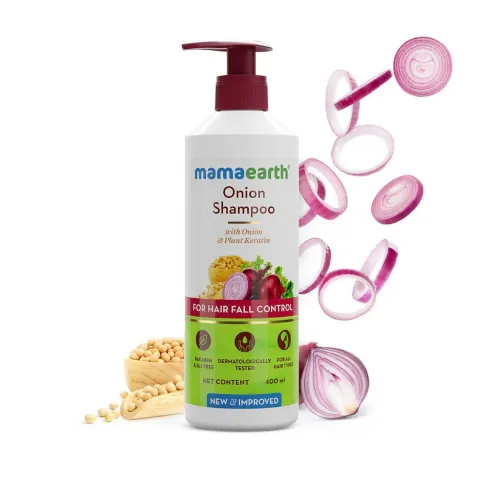 Mamaearth Onion Shampoo bottle with sliced onions and soybean beside it.