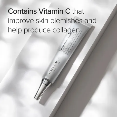 Silver tube of skincare cream on a white surface with soft natural light shadows.