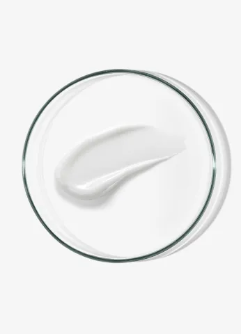 White cream smear on a clear glass dish against a light background.