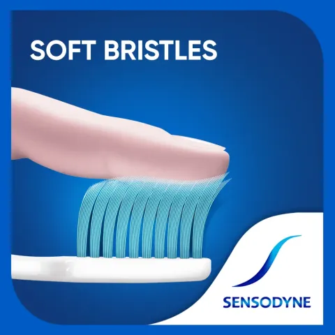 Finger pressing soft blue bristles of a white toothbrush with Sensodyne logo in the corner.