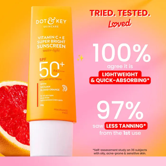 Dot & Key Vitamin C+E sunscreen tube on a pink background beside a grapefruit slice.