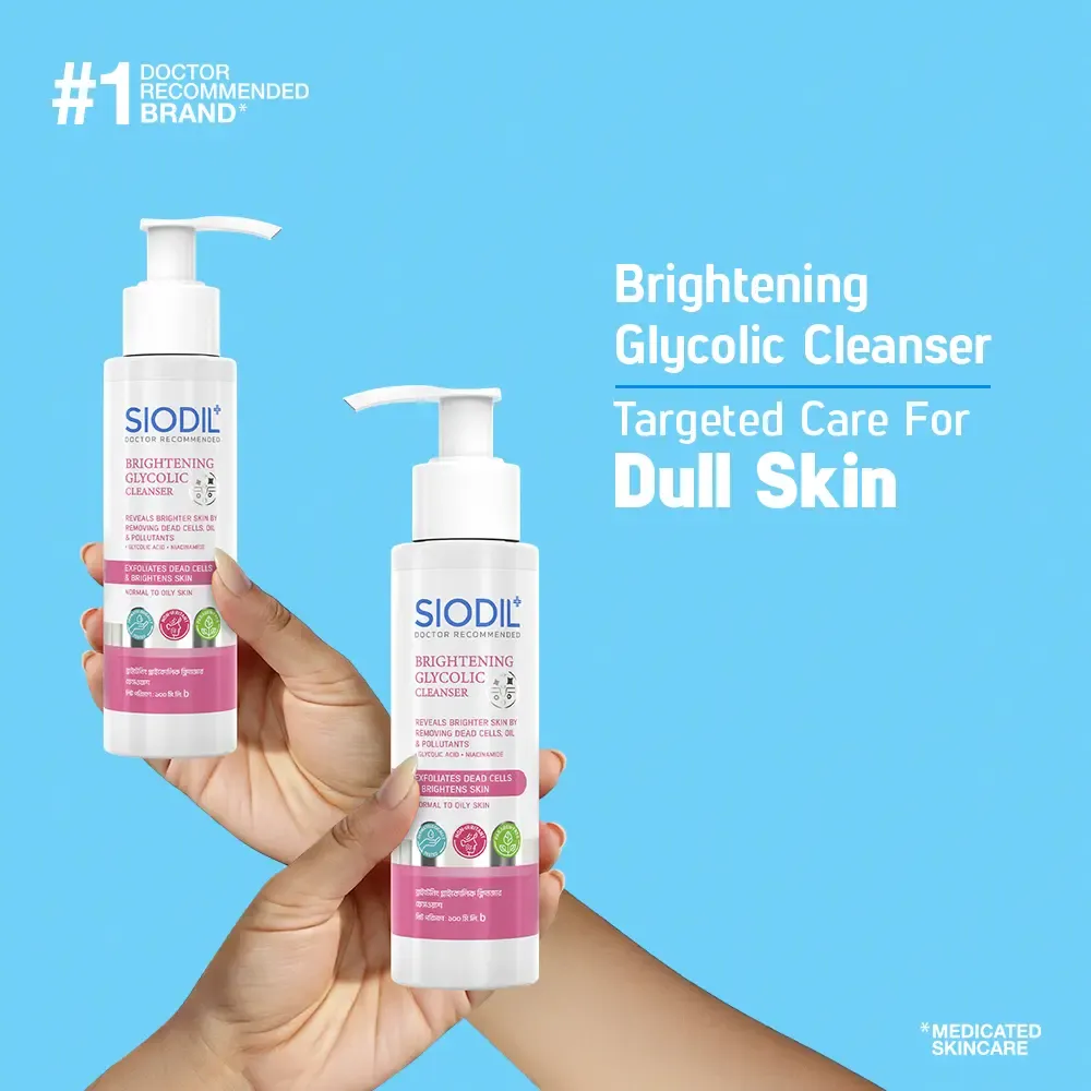 Two hands holding bottles of Siodic brightening glycolic cleanser against a blue background.