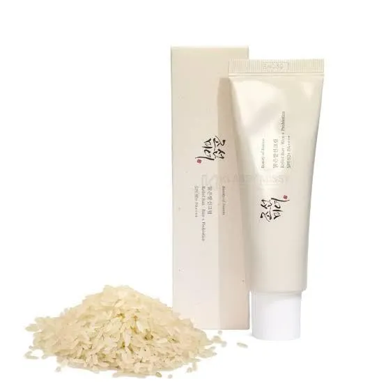 Beige skincare tube and box next to a small pile of rice.