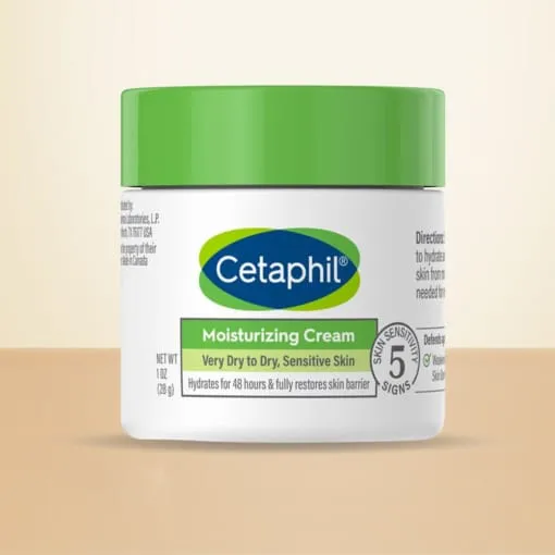 Cetaphil Moisturizing Cream jar with a green lid on a beige surface.