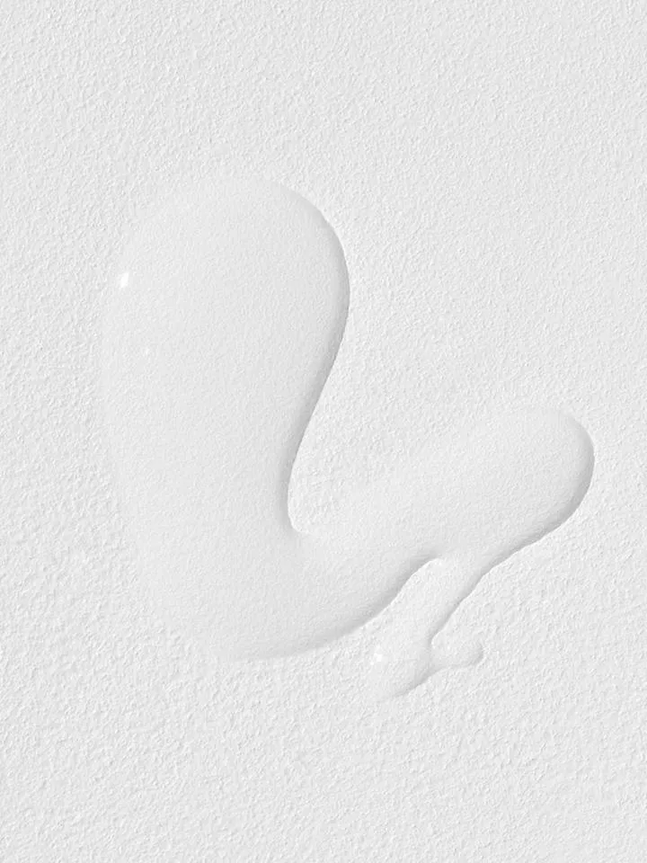 White liquid spill on a textured white surface.