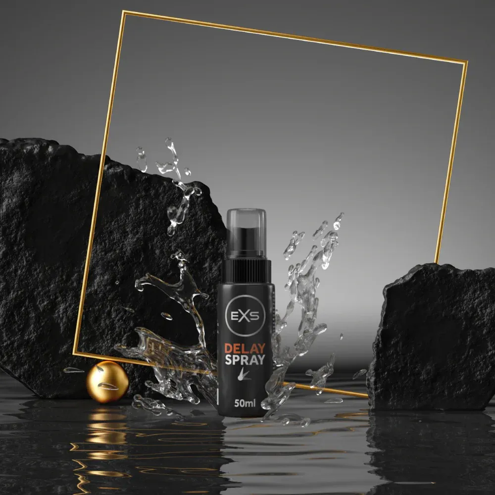 Black spray bottle with gold accents, water splash, rocks, and a gold frame on a reflective surface.