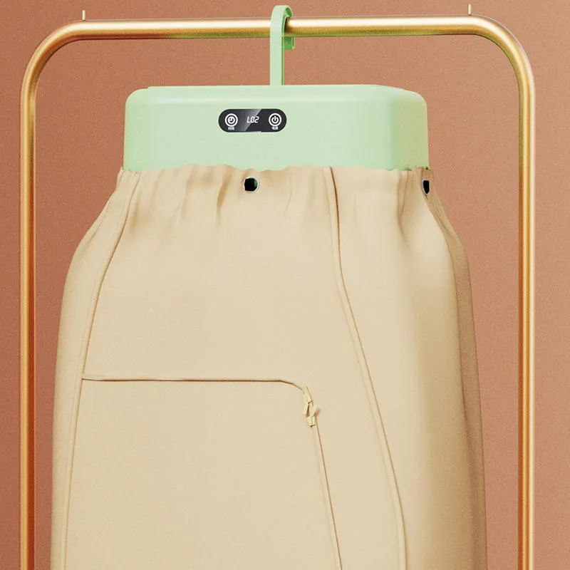 Beige garment steamer with a mint green top on a gold frame against a brown background.