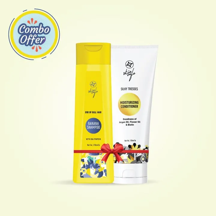 Yellow shampoo bottle and white conditioner tube with a red ribbon on a light background.