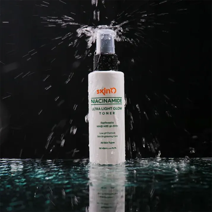 White cosmetic bottle with pump, splashed by water, on reflective surface against black background.